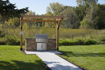 Two outdoor grilling stations with beautiful wooden pergolas